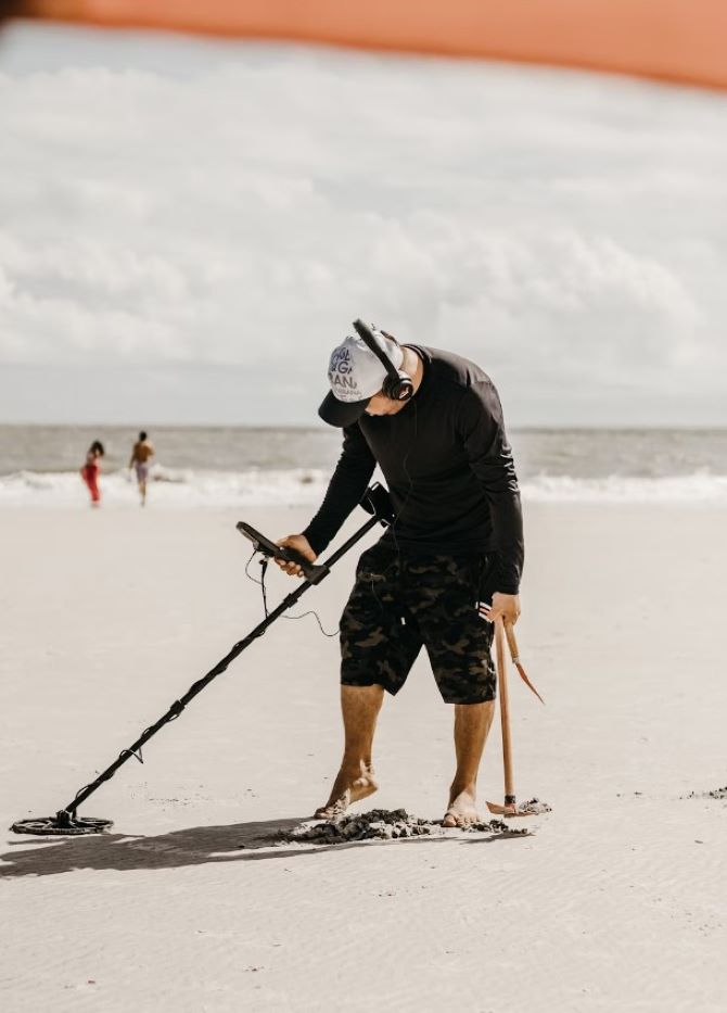 a man holding a stick on the beach